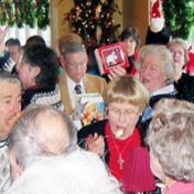 EKURA members hold up their ornaments as part of a Christmas ornament exchange